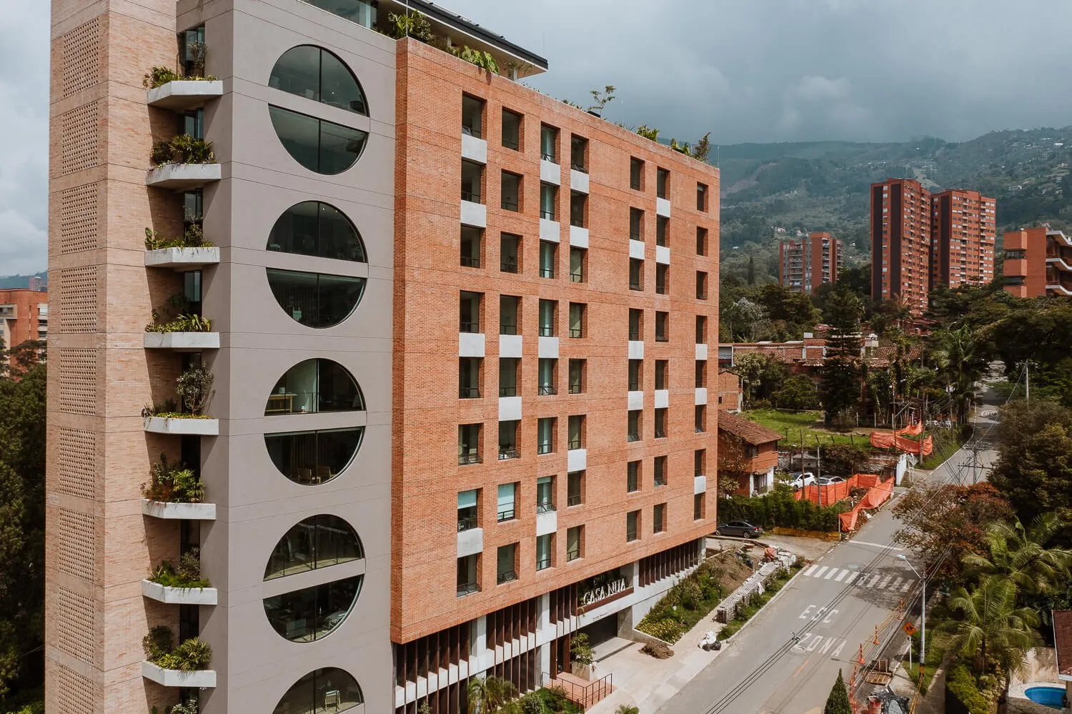 Fachada de Casa Nua San Lucas con las montañas de Medellín al fondo